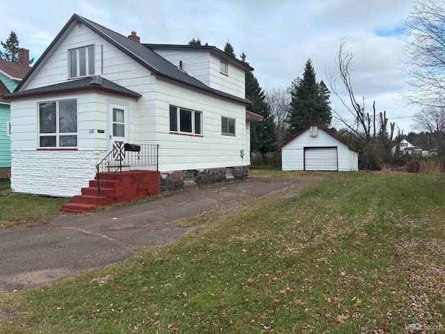 view of front of home with a garage, an outdoor structure, and a front yard