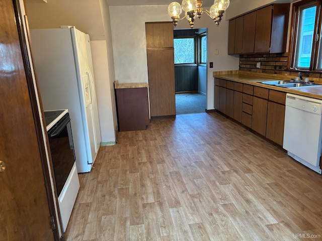 kitchen with tasteful backsplash, white dishwasher, electric range, light hardwood / wood-style floors, and hanging light fixtures