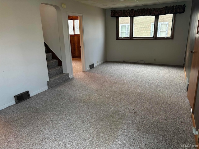 carpeted empty room with a paneled ceiling and a healthy amount of sunlight