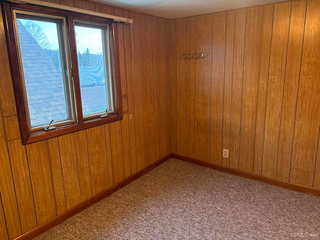 carpeted empty room with wooden walls