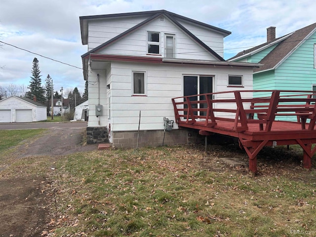 back of house with an outbuilding, a yard, and a wooden deck