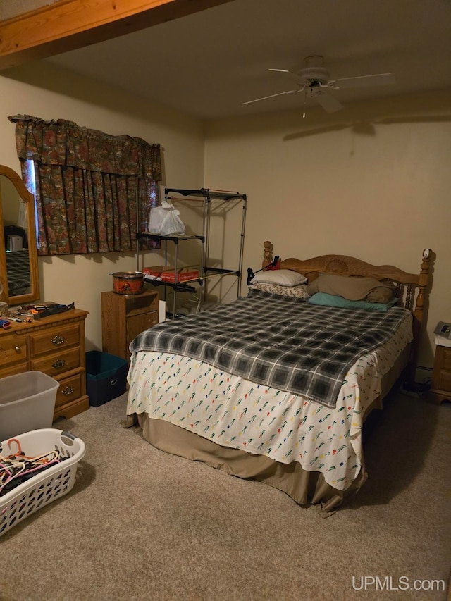 carpeted bedroom with beamed ceiling and ceiling fan