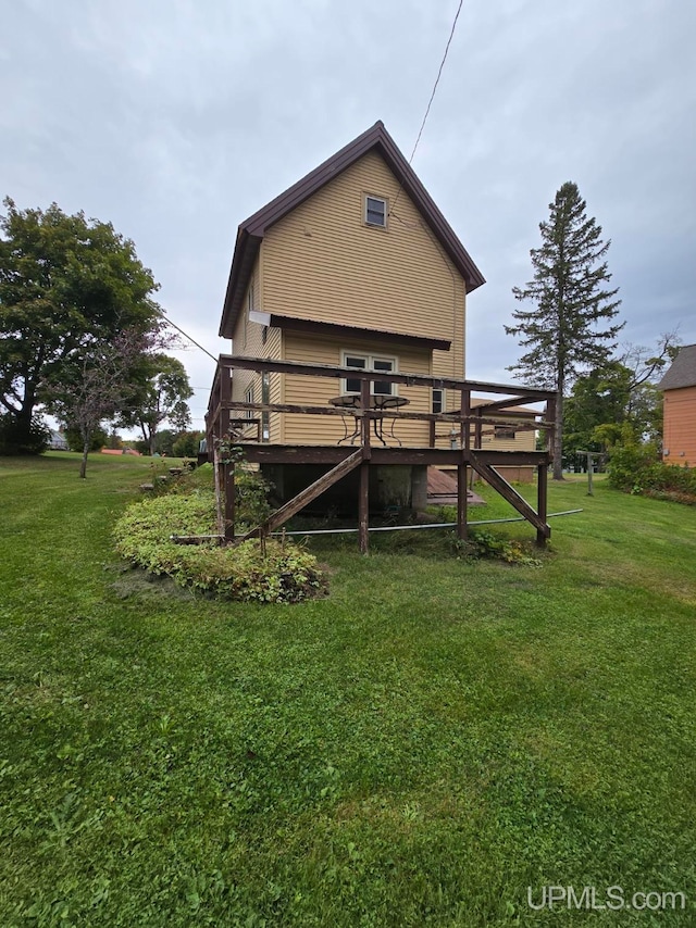 back of property with a lawn and a wooden deck