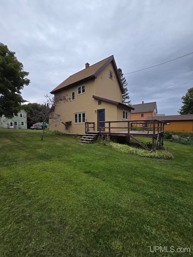 rear view of house with a lawn and a wooden deck