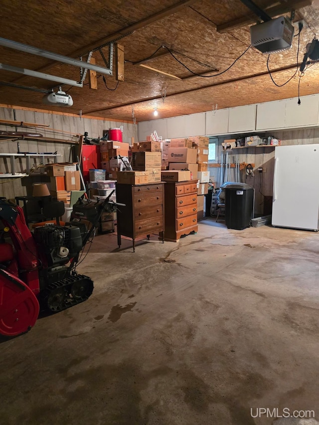 garage with white fridge and a garage door opener