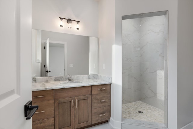 bathroom featuring a tile shower and vanity