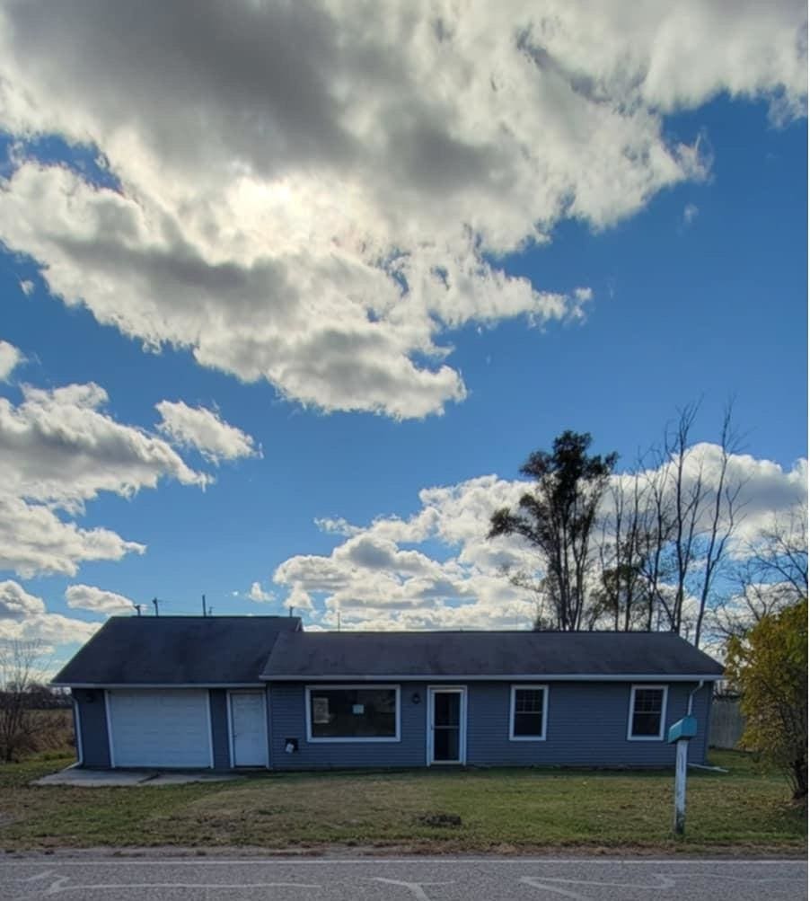 single story home with a garage and a front lawn