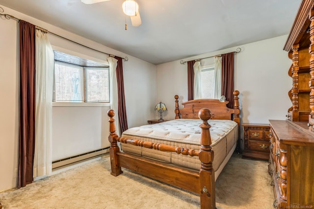 bedroom featuring ceiling fan, light colored carpet, baseboard heating, and multiple windows