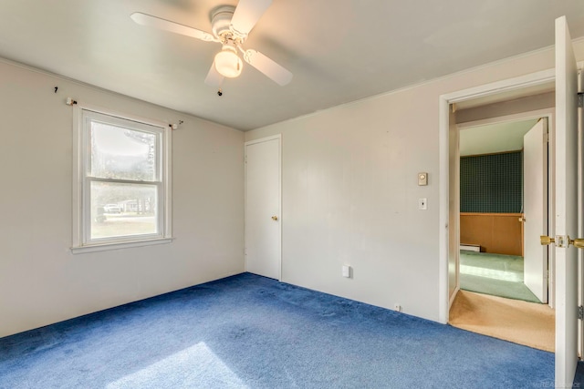 carpeted spare room featuring ceiling fan and a baseboard heating unit