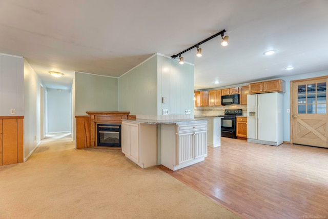 kitchen featuring rail lighting, backsplash, black appliances, light hardwood / wood-style flooring, and a kitchen island