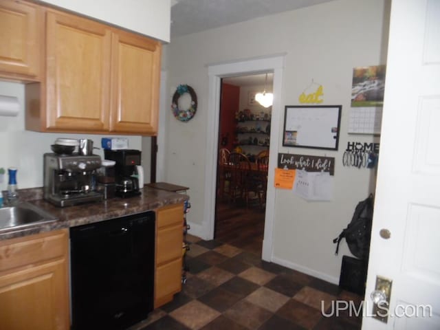 kitchen with light brown cabinetry, dishwasher, and sink