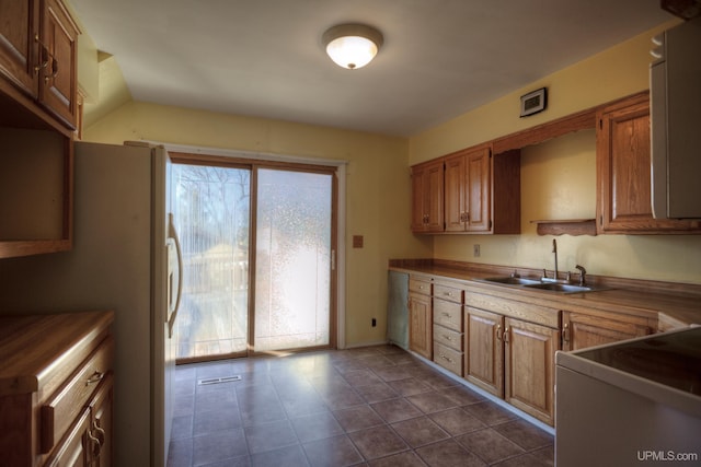 kitchen featuring sink, a healthy amount of sunlight, lofted ceiling, and range