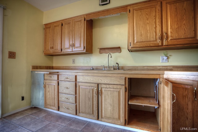 kitchen with dark tile patterned floors and sink