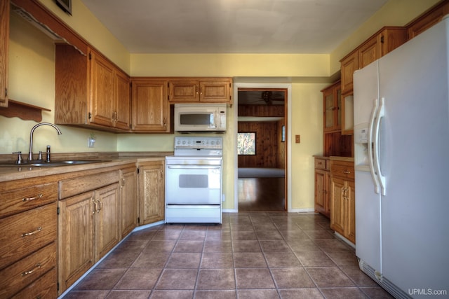 kitchen featuring sink, dark tile patterned floors, and white appliances