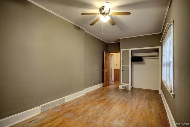 unfurnished bedroom featuring light wood-type flooring, multiple windows, ornamental molding, and ceiling fan