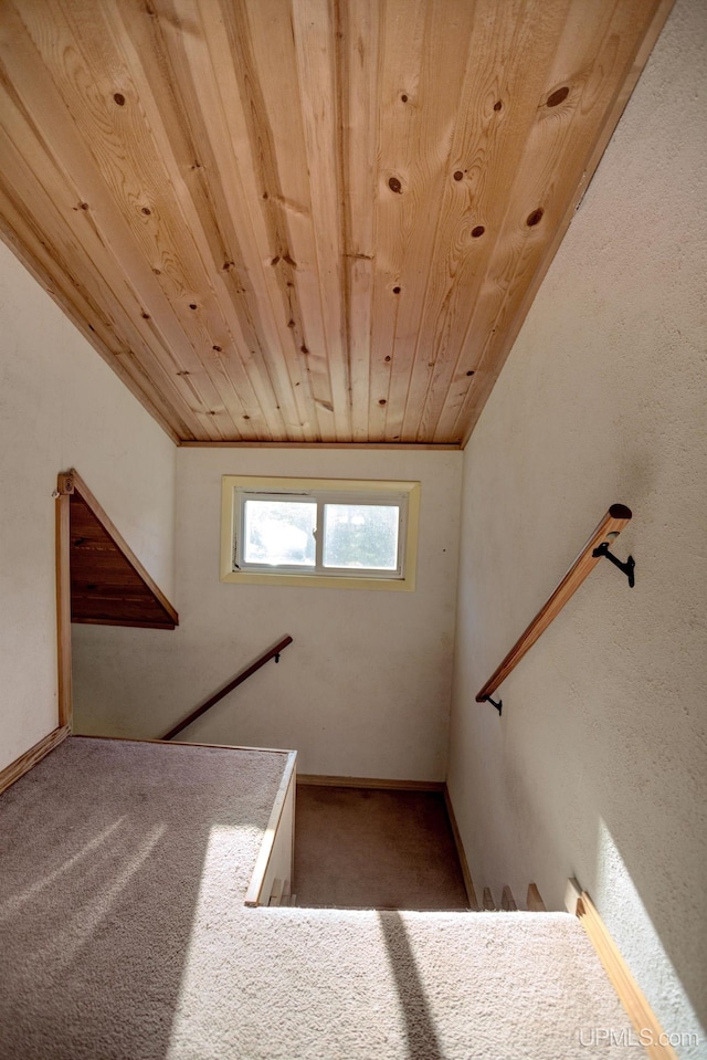 stairs with carpet flooring, vaulted ceiling, and wooden ceiling