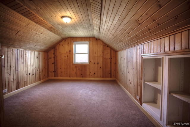 additional living space with carpet flooring, lofted ceiling, wood ceiling, and wooden walls