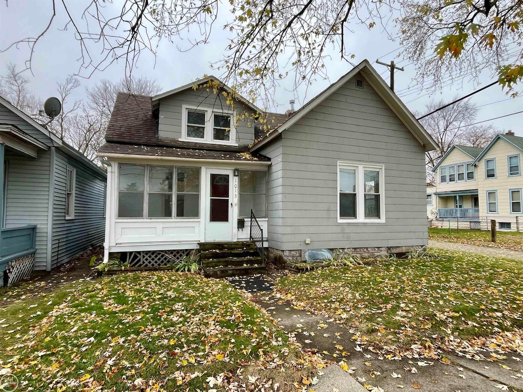 rear view of property featuring a lawn