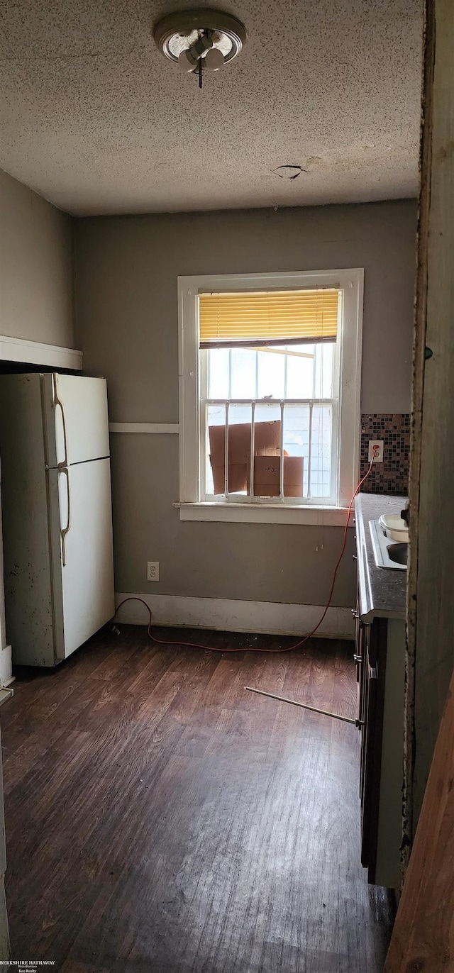 kitchen with a textured ceiling, dark hardwood / wood-style floors, white refrigerator, and sink