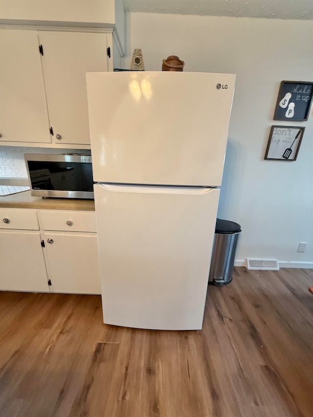 kitchen featuring white refrigerator, white cabinetry, and light hardwood / wood-style flooring