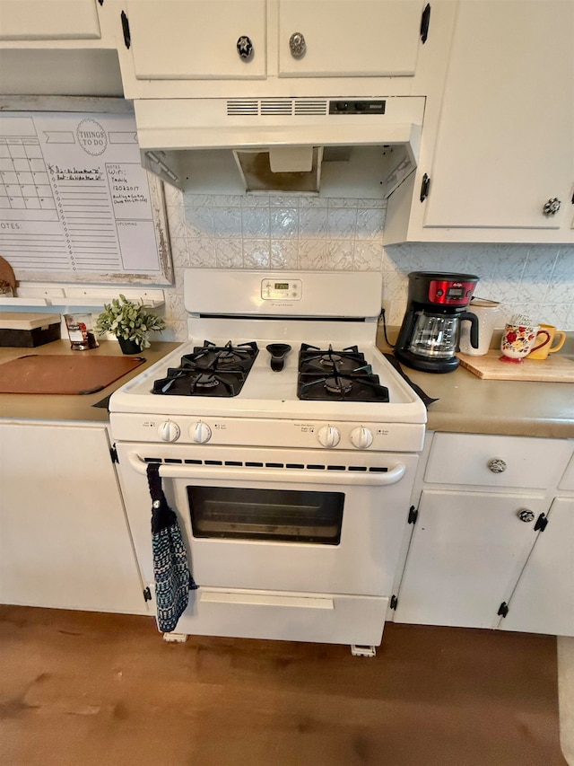 kitchen featuring backsplash, white cabinetry, and white gas range