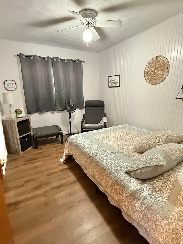 bedroom with ceiling fan and wood-type flooring