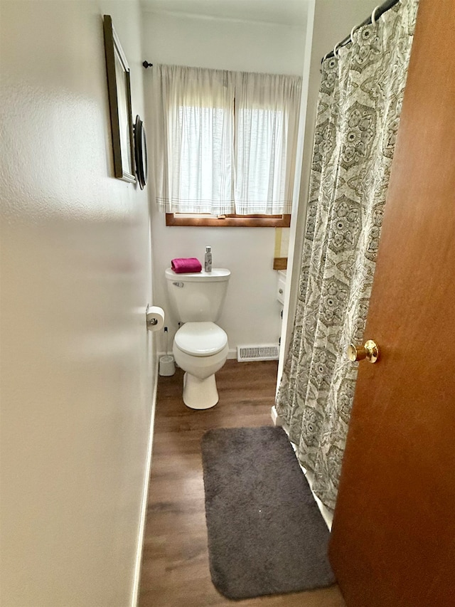 bathroom featuring wood-type flooring and toilet