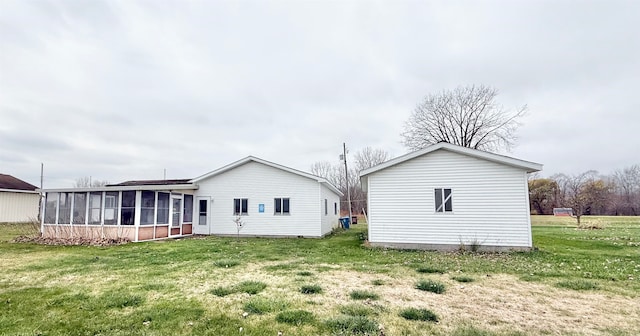 back of house with a sunroom and a yard