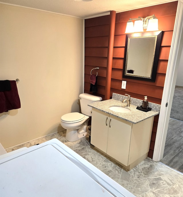 bathroom featuring hardwood / wood-style floors, vanity, toilet, and a textured ceiling