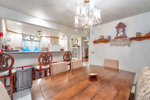 dining space featuring ceiling fan with notable chandelier