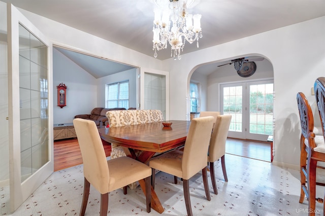 dining area featuring french doors, light hardwood / wood-style floors, lofted ceiling, and an inviting chandelier