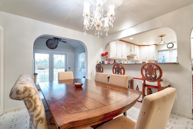 dining room with french doors and ceiling fan with notable chandelier