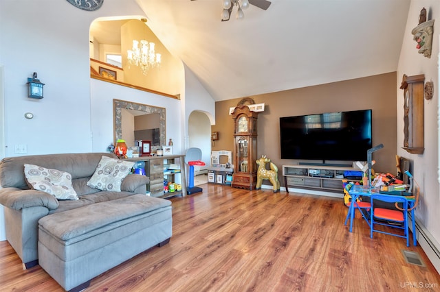 living room featuring ceiling fan with notable chandelier, hardwood / wood-style flooring, high vaulted ceiling, and a baseboard radiator