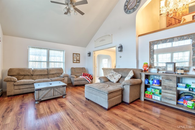 living room with ceiling fan, plenty of natural light, high vaulted ceiling, and hardwood / wood-style floors