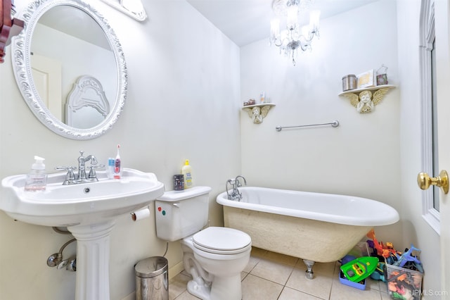 bathroom with tile patterned floors, toilet, a tub, and an inviting chandelier