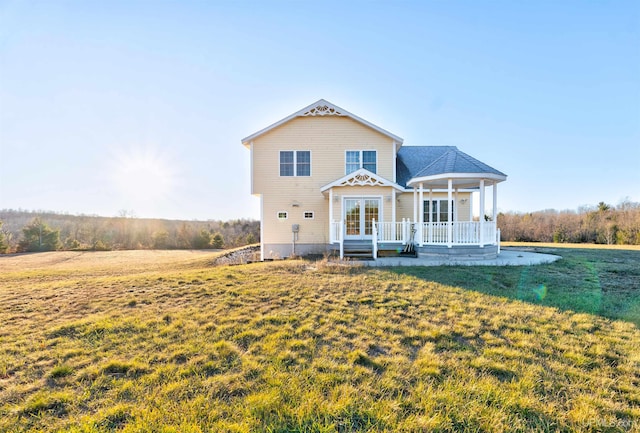 rear view of property with a yard and a porch