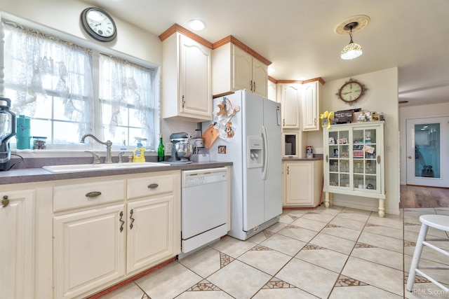 kitchen featuring light tile patterned floors, white appliances, sink, and hanging light fixtures