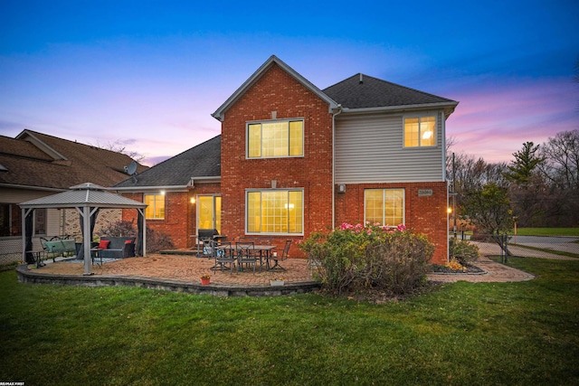 back house at dusk featuring a gazebo, a patio area, outdoor lounge area, and a yard