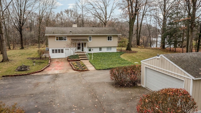 split foyer home with a garage and a front yard