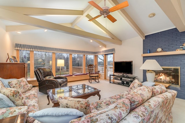 living room with beamed ceiling, carpet flooring, ceiling fan, and a brick fireplace