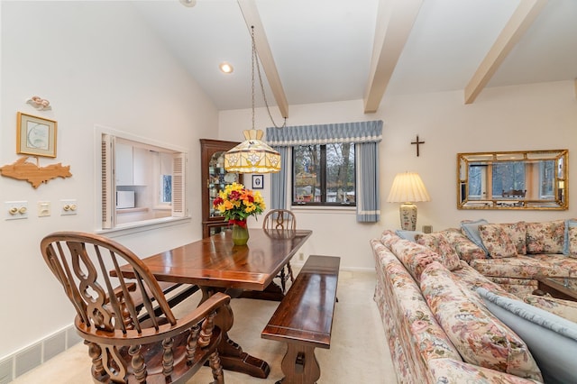 carpeted dining space featuring lofted ceiling with beams