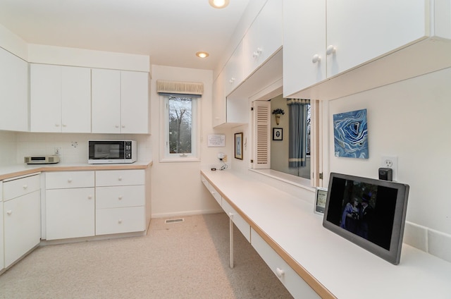 kitchen with tasteful backsplash and white cabinets