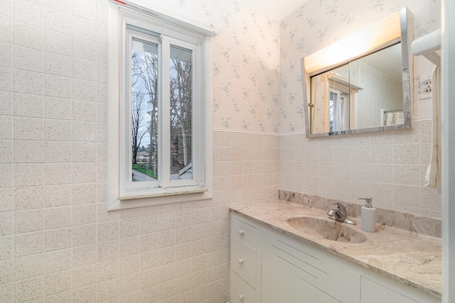 bathroom featuring vanity and tile walls