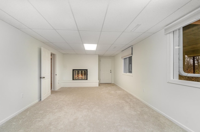 basement featuring light carpet and a drop ceiling