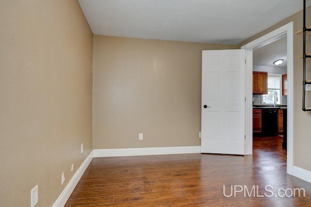 spare room with sink and dark wood-type flooring