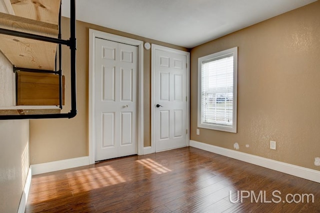 unfurnished bedroom with hardwood / wood-style floors