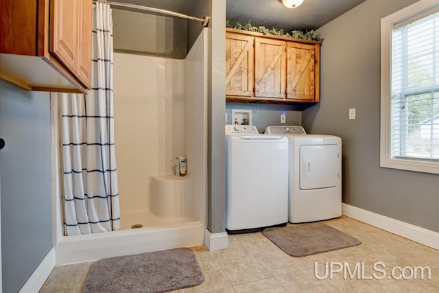 washroom with cabinets, light tile patterned flooring, and washer and dryer