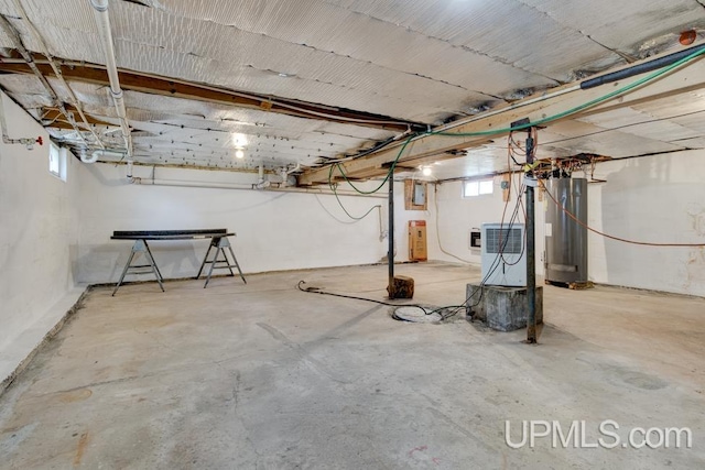 basement featuring electric panel and water heater