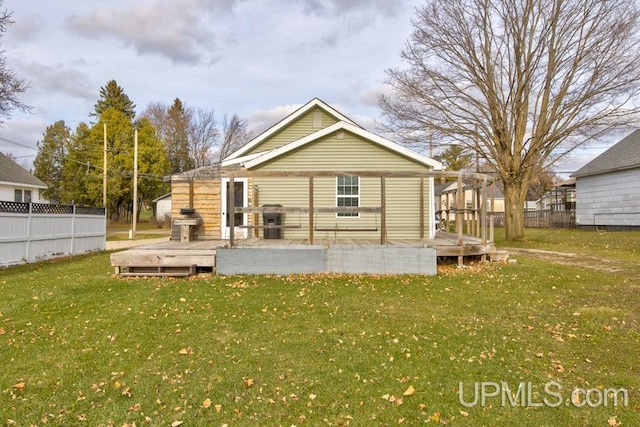 back of house with a lawn and a wooden deck