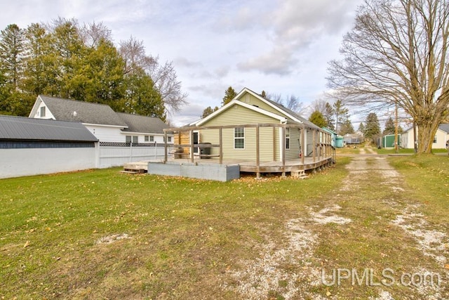 rear view of house with a yard and a deck